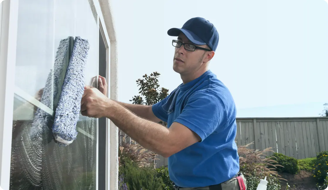 a man in blue outfit cleaning a window