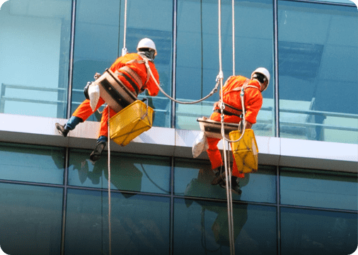 two people cleaning a glass building