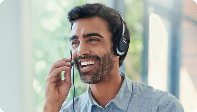 A smiling man on a phone call in a cafeteria