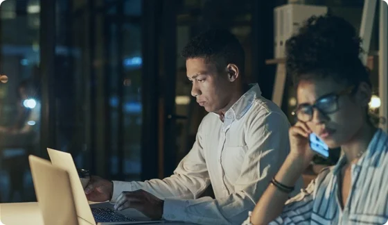 two people working in front of a laptop