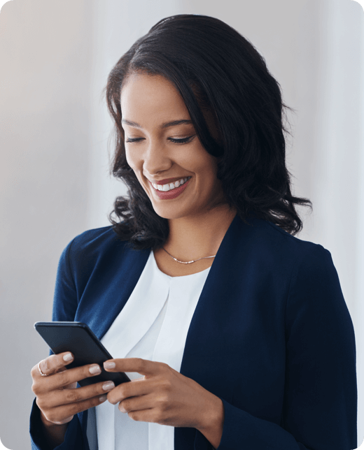 A smiling woman in blue blazer looking at her phone