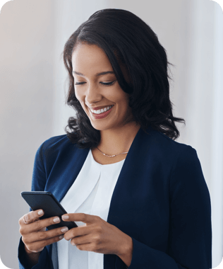 A smiling woman in blue blazer looking at her phone