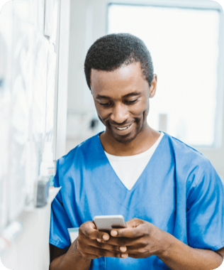 A smiling woman looking at her laptop wearing headphones