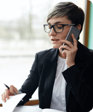 A smiling woman looking at her laptop wearing headphones