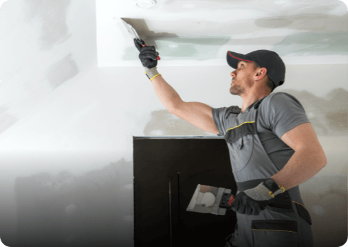 a man plastering the ceiling