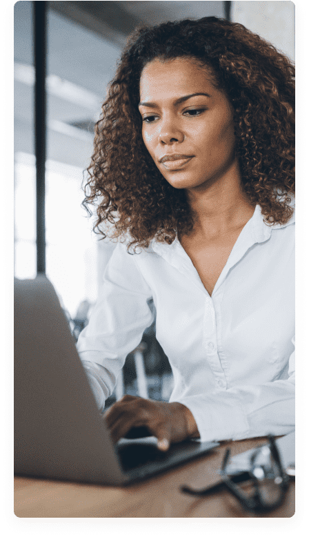 a curly haired woman working on a laptop